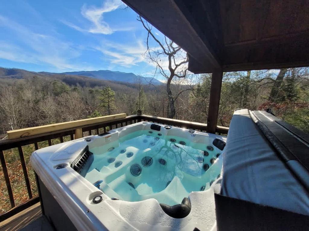 a hot tub on a deck with a view of the mountains at Great View Location Studio Log Cabin Hot Tub in Gatlinburg