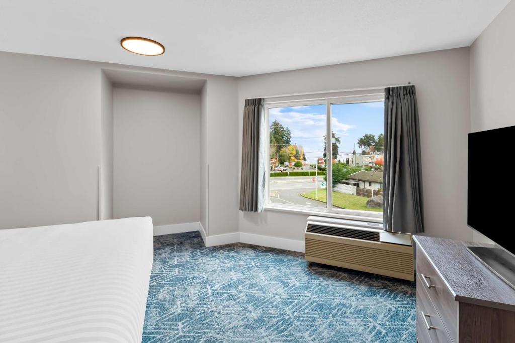 a room with a bed and a large window at Hotel Feng, BW Signature Collection in Parksville
