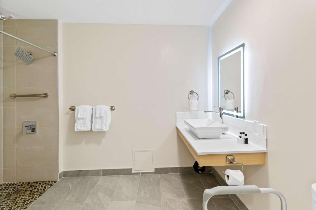a white bathroom with a sink and a shower at Hotel Feng, BW Signature Collection in Parksville
