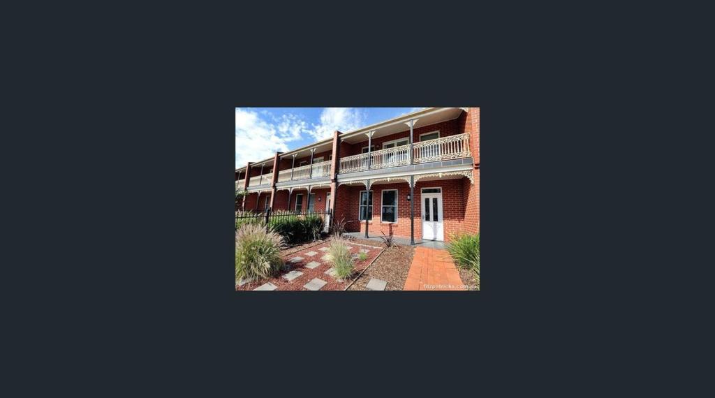 an apartment building with a balcony and a courtyard at City Townhouse Escape 4 in Wagga Wagga
