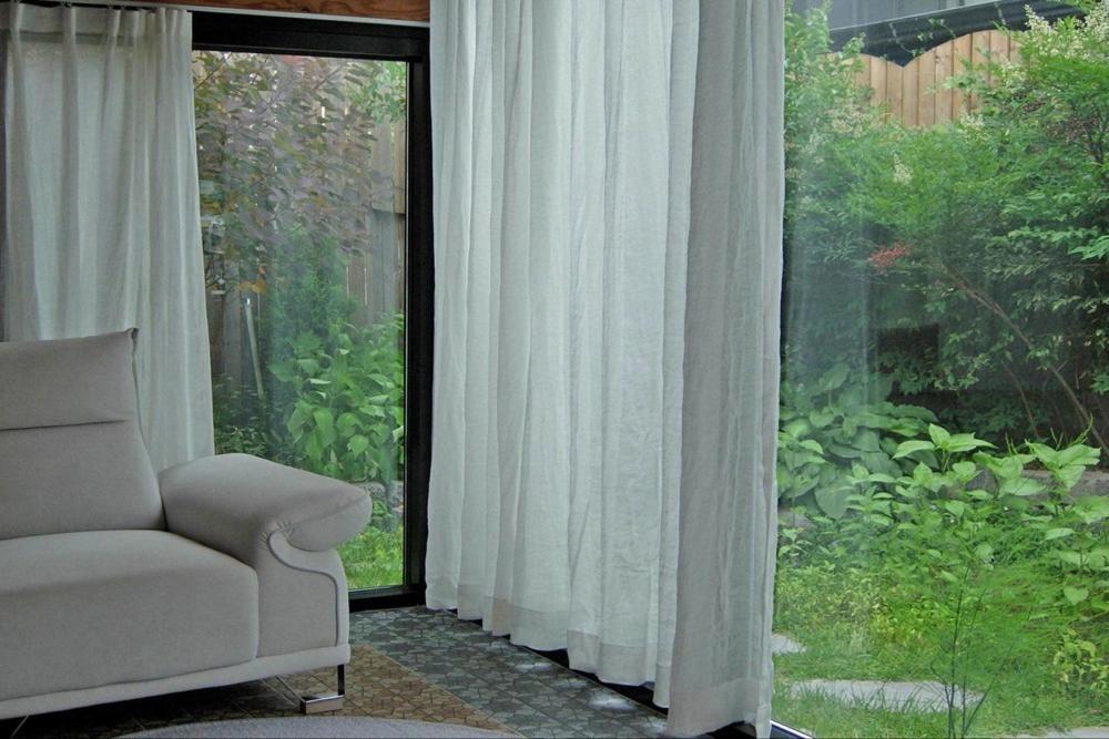 a living room with a chair and a large window at Tasha's Garden Private Pension Jeonju Hanok Village in Jeonju