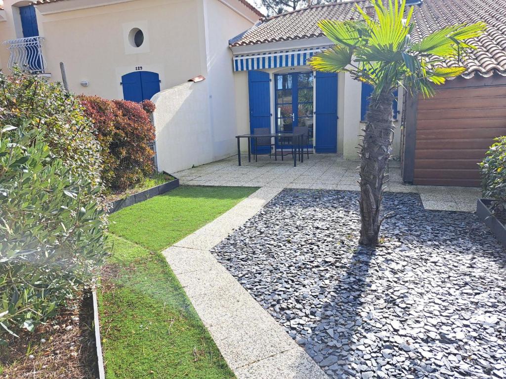 un palmier devant une maison dans l'établissement Maison charmante proche pistes cyclables, animaux admis - FR-1-323-567, à Saint-Jean-de-Monts