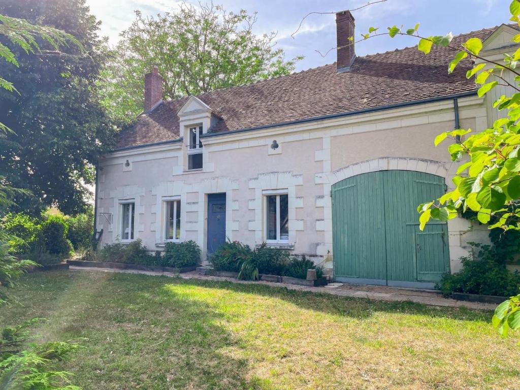 an old white house with a green garage at Maison 8 min du Zoo de Beauval, jardin, cheminée, tout inclus, proche Châteaux de la Loire - FR-1-491-429 in Châteauvieux