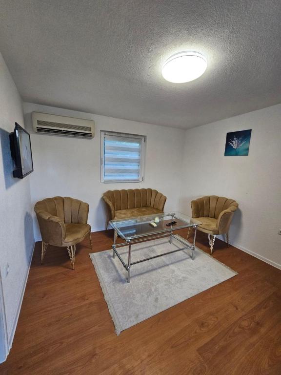 a living room with two chairs and a glass table at Apartman Alina&Alan 2 in Bihać