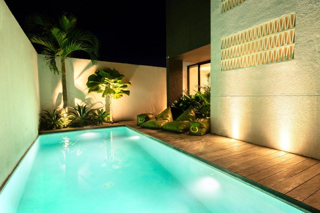 チャングーにあるHanupis Canggu Apartment Villaの植物が植えられた家の中のスイミングプール