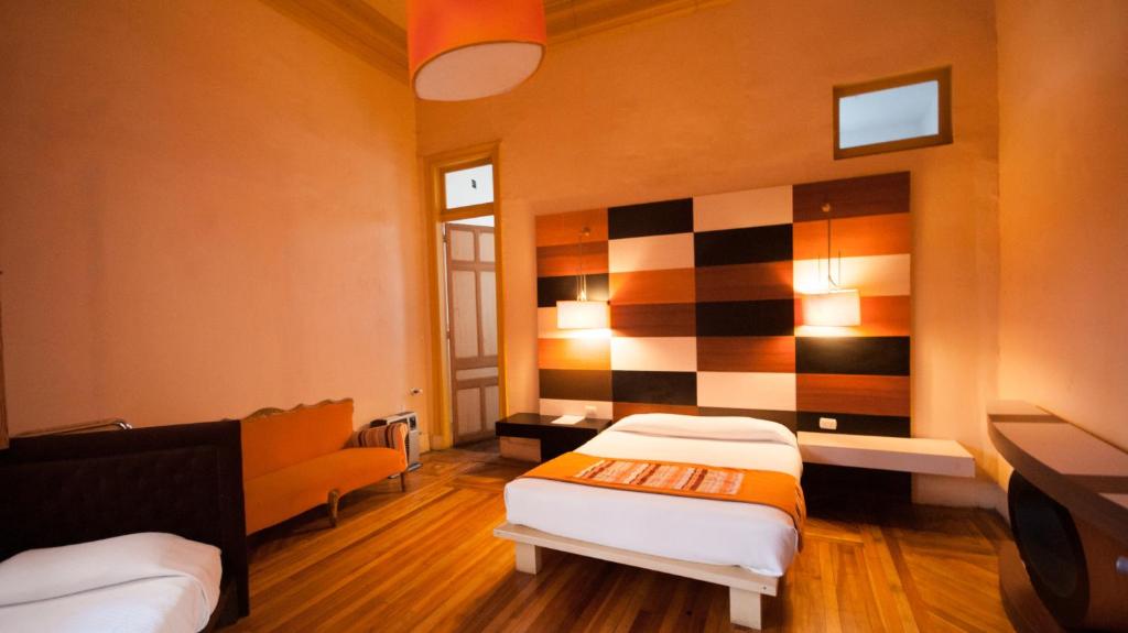 a room with two beds and a checkered wall at Happy House Hostel in Santiago