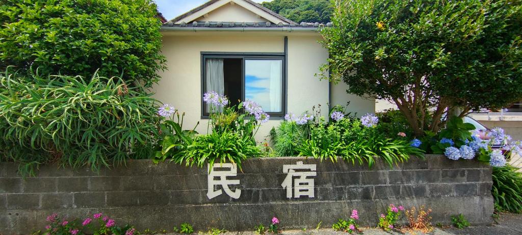 a house with flowers in front of it at Izu Hokkawa Seaside Guesthouse 伊豆北川の家 in Higashiizu