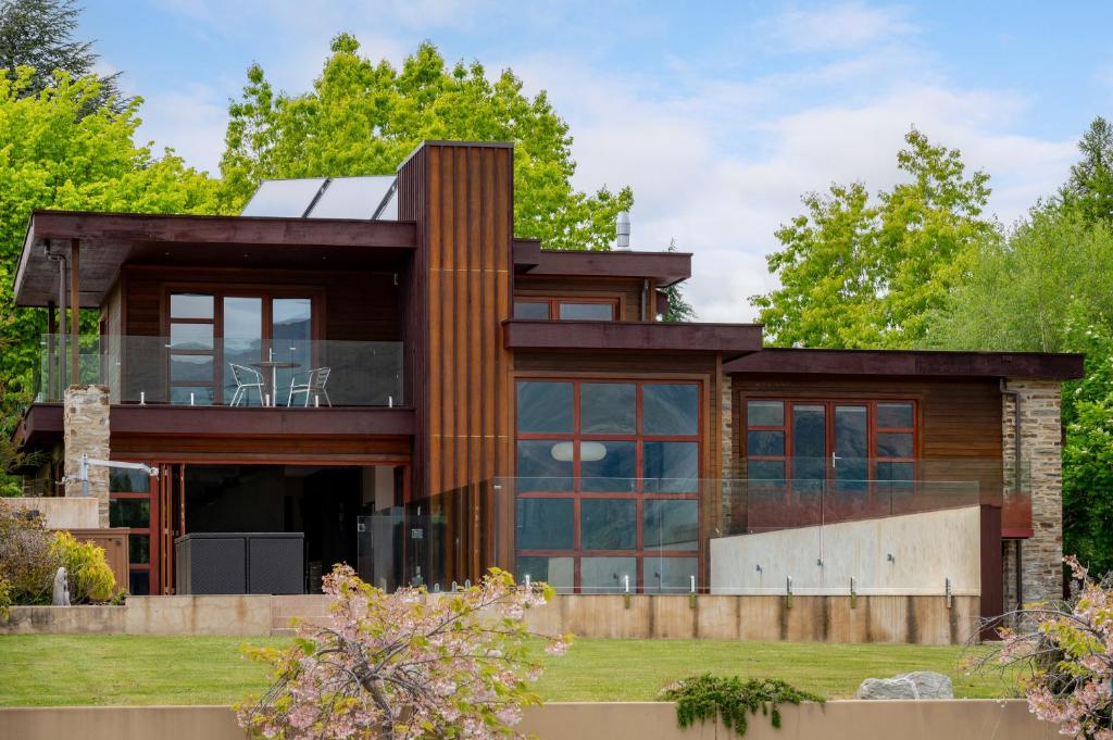 a contemporary house with glass windows and wood at Macpherson Street, Wanaka in Wanaka