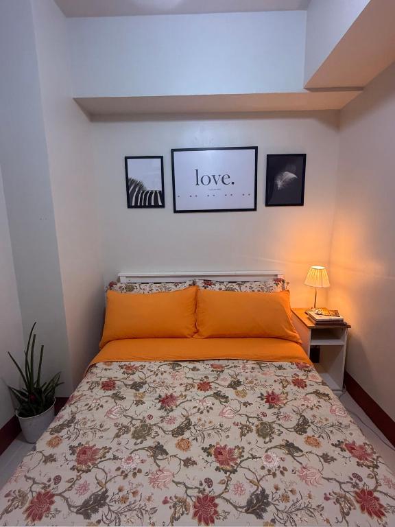 a bedroom with a bed with an orange bedspread at Obetskie's Haven Condotel in Manila