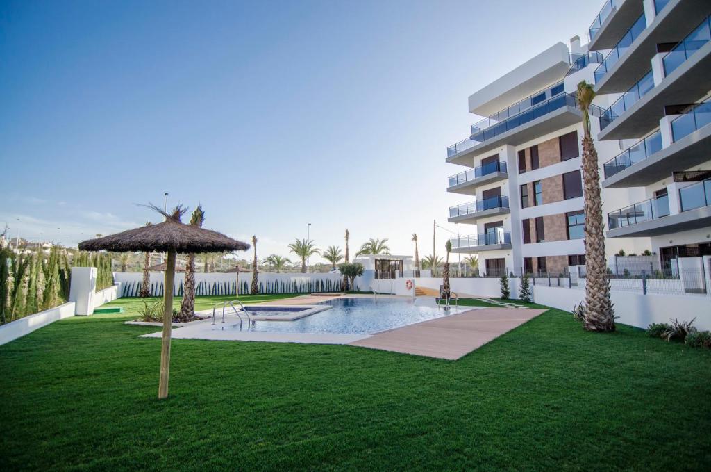 a swimming pool with an umbrella next to a building at Arenales Playa Superior by Mar Holidays in Arenales del Sol