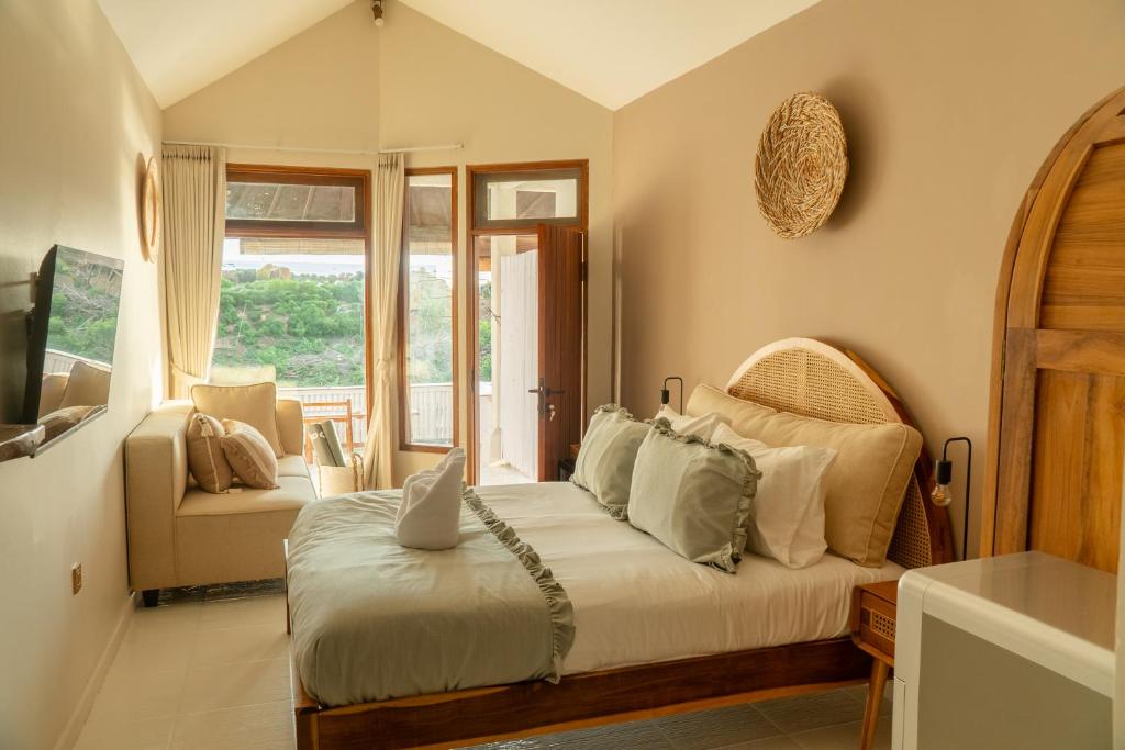une chambre avec un lit, un canapé et une télévision dans l'établissement Uluwatu Ocean Front Surf Suite, à Uluwatu