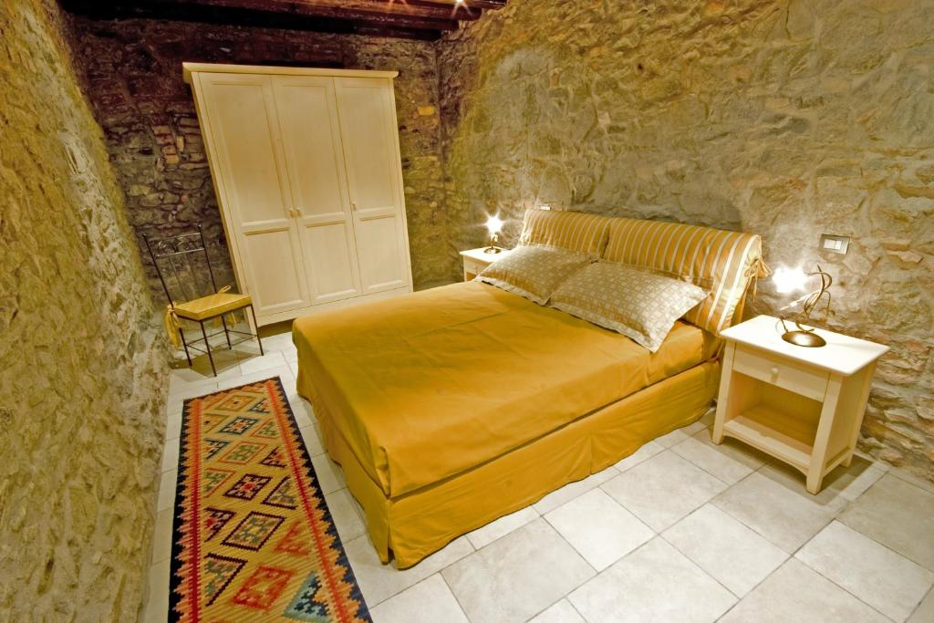 ein Schlafzimmer mit einem Bett in einer Steinmauer in der Unterkunft Aiceltis in Teolo