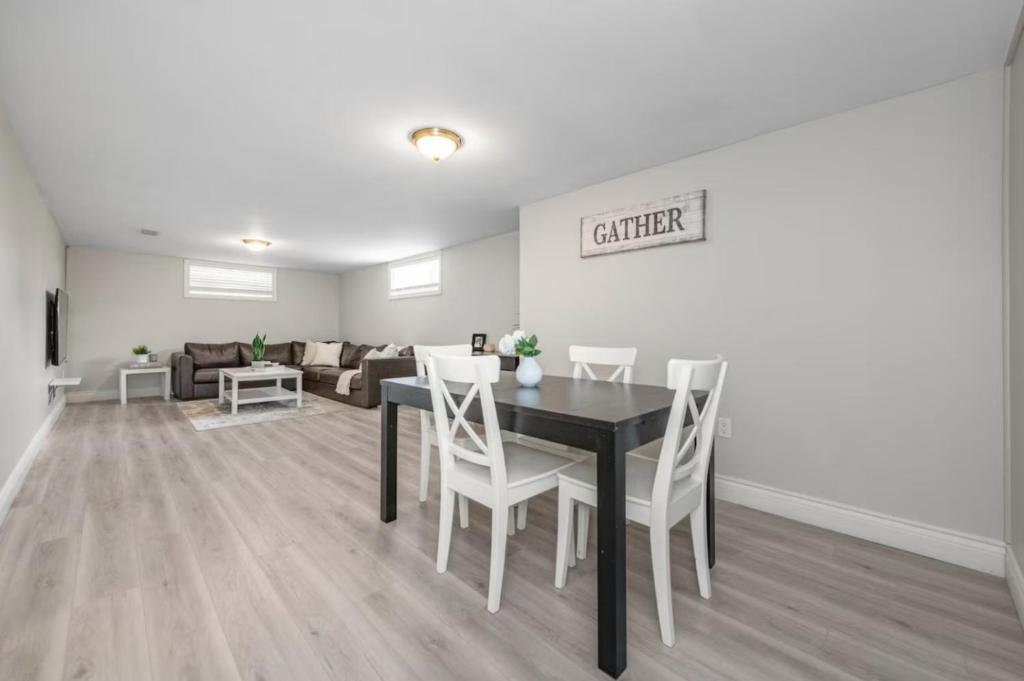 a dining room with a table and chairs and a couch at 1913 rosebella in Ottawa
