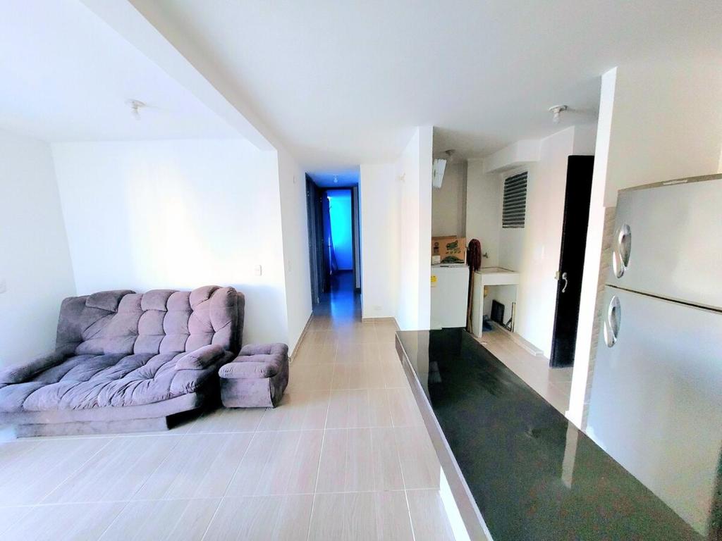a living room with a couch and a refrigerator at Bonito Aparatemnto con Piscina in Santa Marta