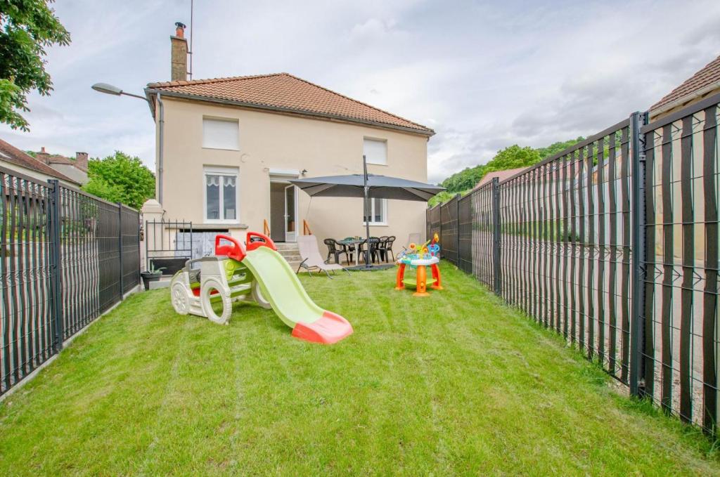 Un patio trasero con un tobogán y un parque infantil. en Au vieux bahut, 
