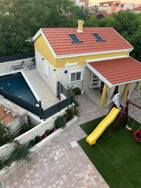an overhead view of a house with a pool and a slide at Hidden Oasis - pool, playground - 3 min from the beach in Vir