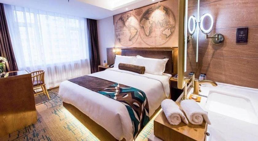 a hotel room with a large bed and a bath tub at James Joyce Coffetel Changchun People's Square in Changchun