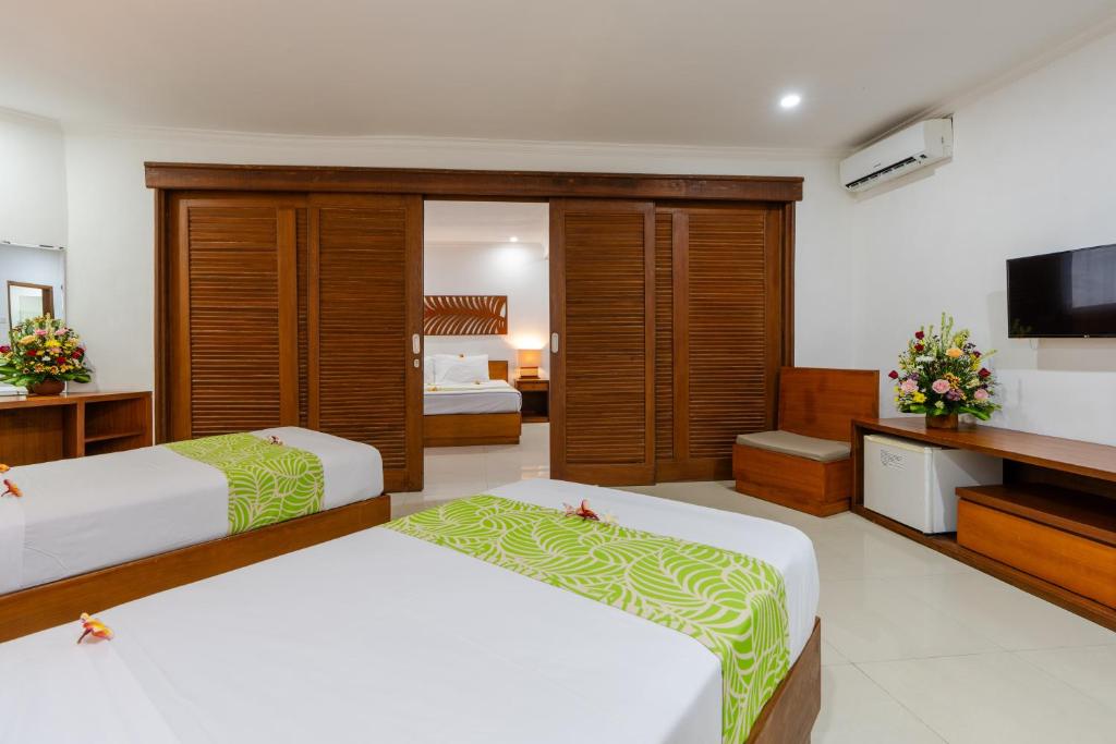 Postel nebo postele na pokoji v ubytování Dewi Sri Hotel