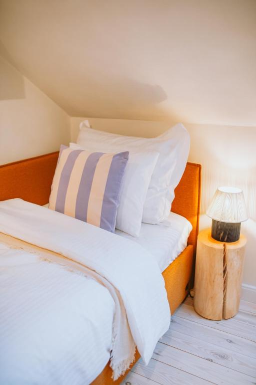 a bedroom with a bed with white pillows and a lamp at Saieta 2 Apartment II in Madona