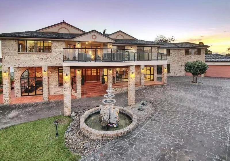 a large house with a fountain in front of it at 6bed Macgregor Home in Brisbane