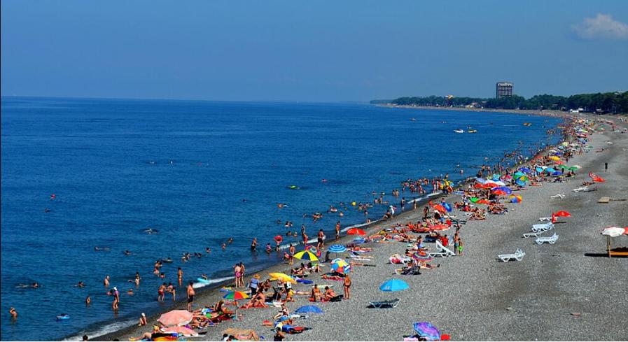a crowd of people on a beach with umbrellas at Kobuleti Central in K'obulet'i