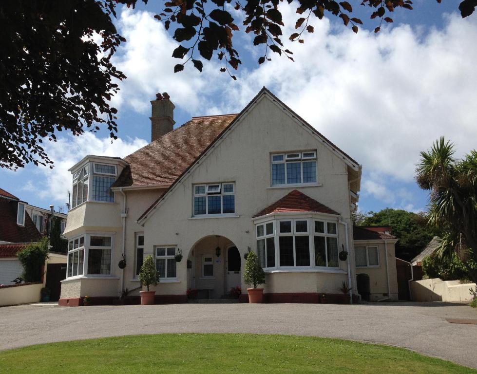 a large white house with blue windows at Copper Beech Rooms in Newquay