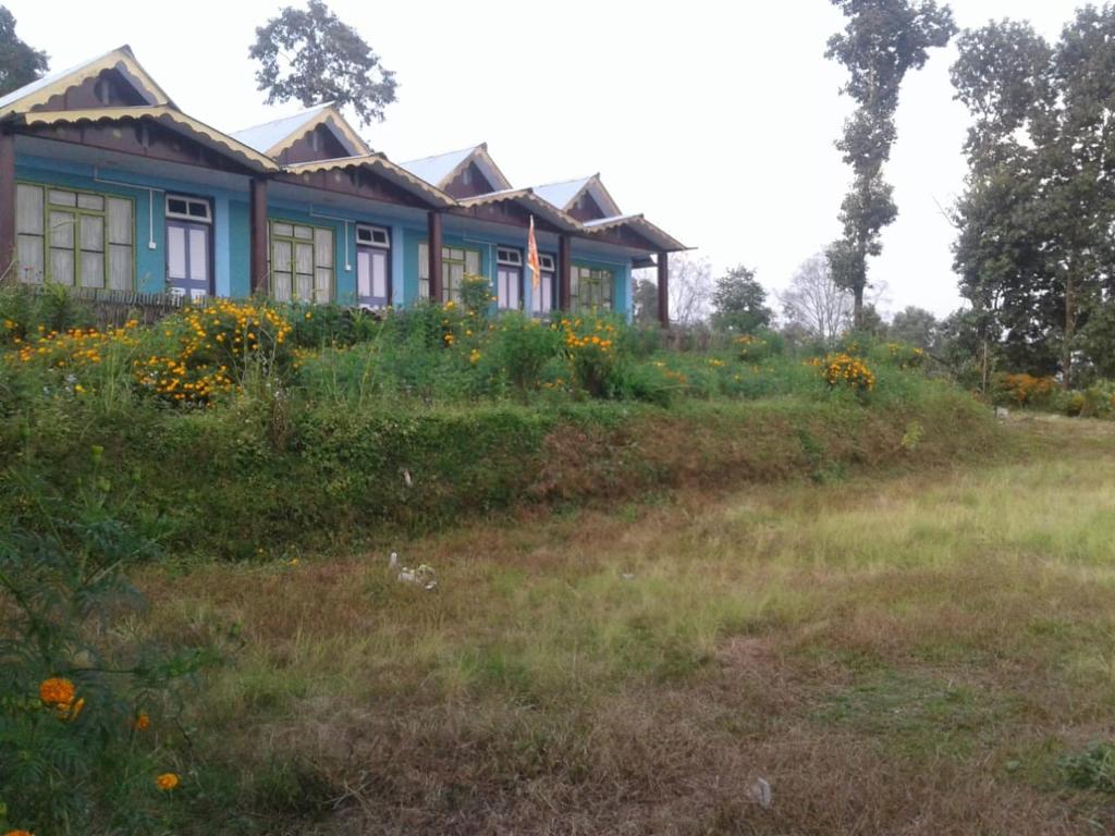 a house on a hill with a field of flowers at Sai Lakshmi Homestay in Pedong
