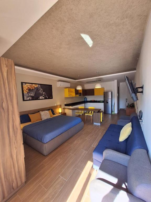 a bedroom with a blue bed and a couch at George Luxury Condo in Playa del Carmen