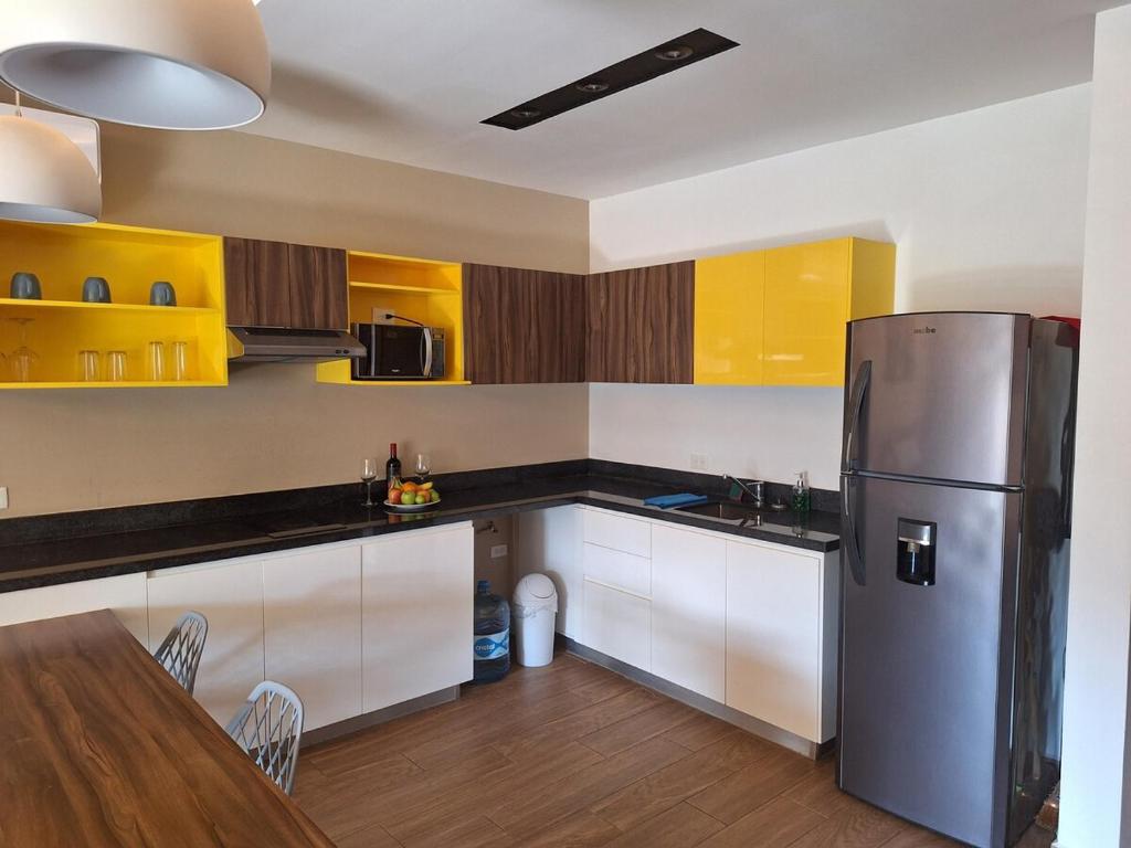 a kitchen with a stainless steel refrigerator and a table at George Luxury Condo in Playa del Carmen