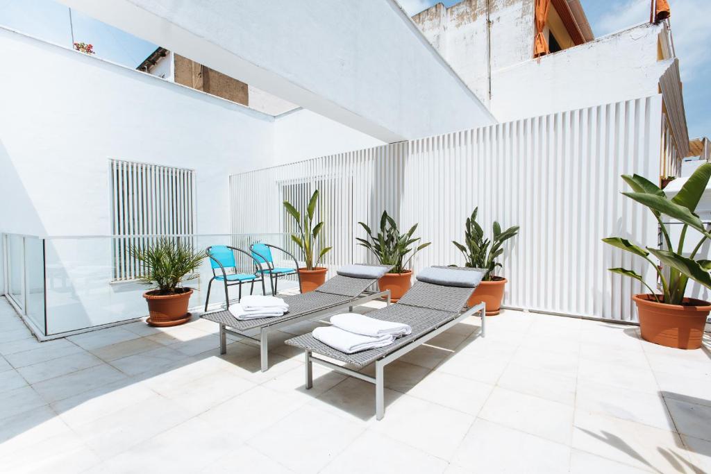 a patio with chairs and plants in a building at Singular Virgenes in Seville