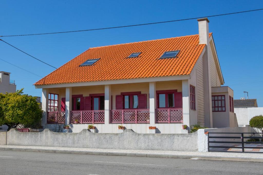 una casa con techo naranja en una calle en Casa Palheiro Amarelo da Biarritz, en Costa Nova