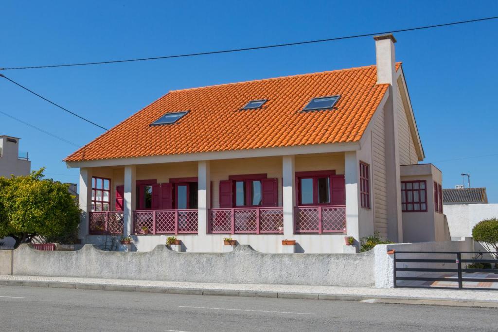 una casa con tetto arancione su una strada di Casa Palheiro Amarelo da Biarritz a Costa Nova