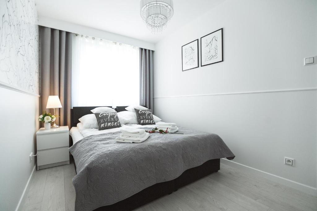 een witte slaapkamer met een bed en een raam bij Silver Apart Rzeszów in Rzeszów
