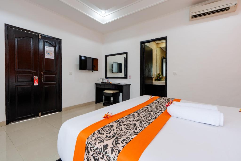 Postel nebo postele na pokoji v ubytování Dewi Sri Hotel