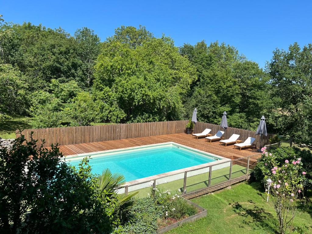 a swimming pool in a backyard with a wooden fence at Gîte Dordogne Périgord in Hautefort