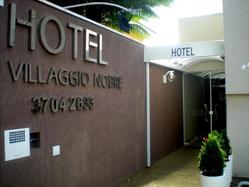 a hotel sign on the side of a building at Hotel Villaggio Nobre in Limeira