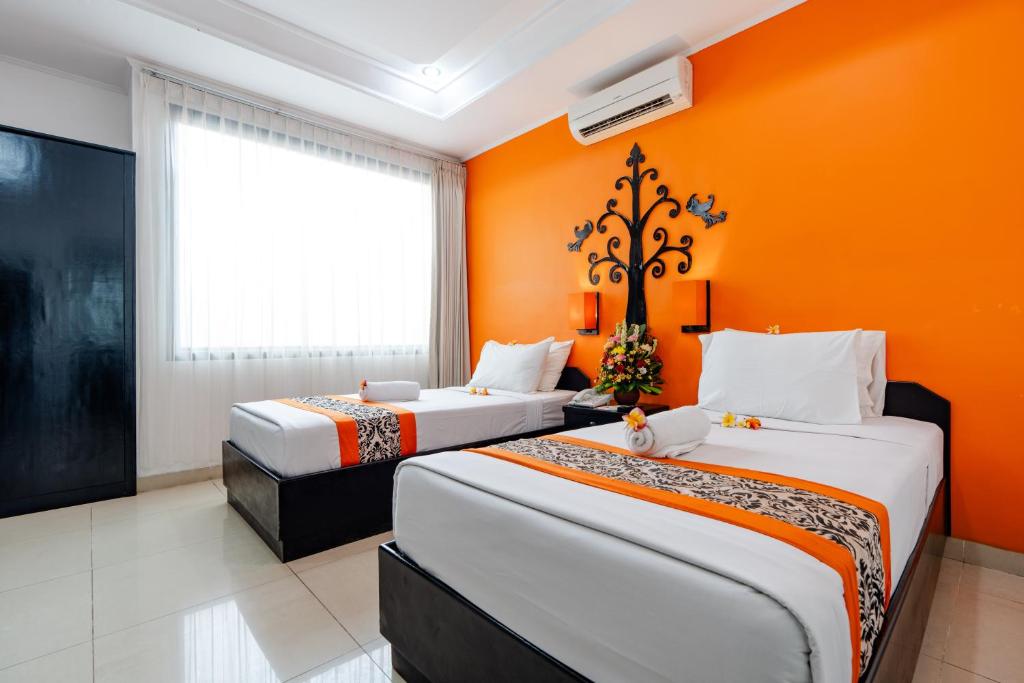 Postel nebo postele na pokoji v ubytování Dewi Sri Hotel