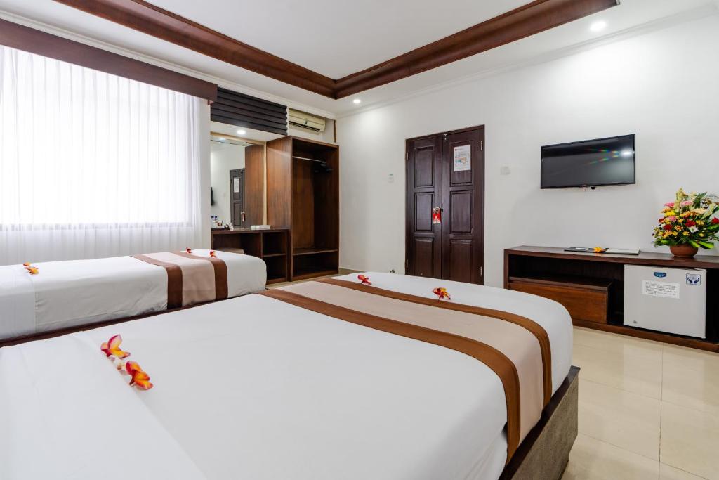 Postel nebo postele na pokoji v ubytování Dewi Sri Hotel