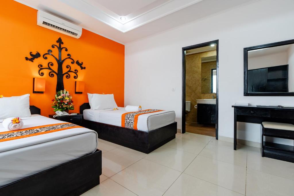 Postel nebo postele na pokoji v ubytování Dewi Sri Hotel