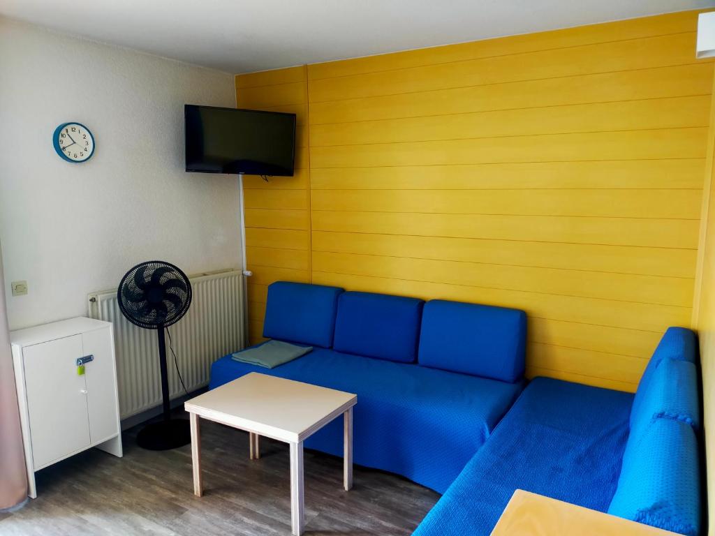 a living room with a blue couch and a table at T2 au calme résidence avec piscine - Les Hauts de Balaruc in Balaruc-les-Bains