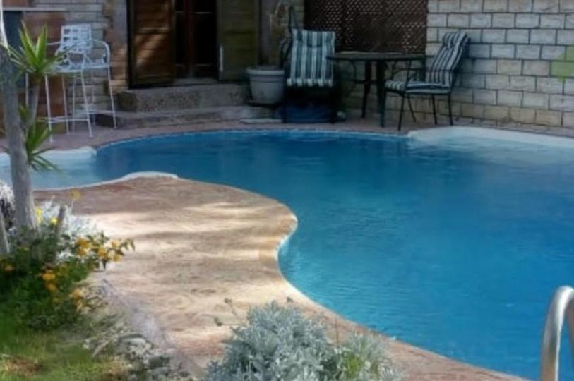 a large blue swimming pool in front of a house at Sou Villa in El Alamein