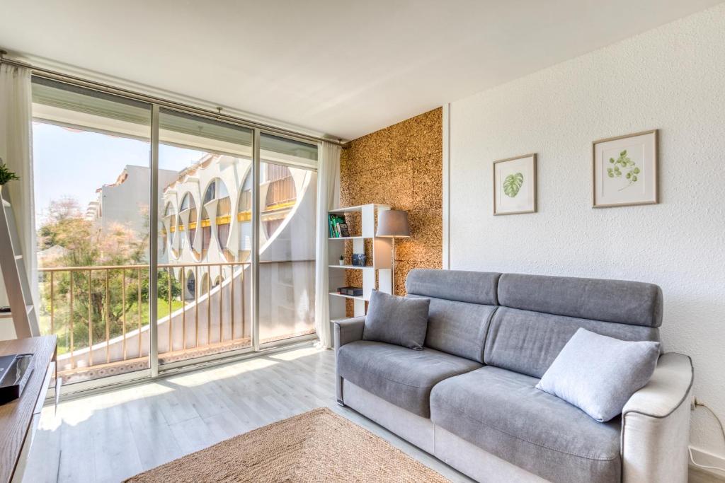 un salon avec un canapé et une grande fenêtre dans l'établissement Appartement à 70m de la plage, à La Grande Motte
