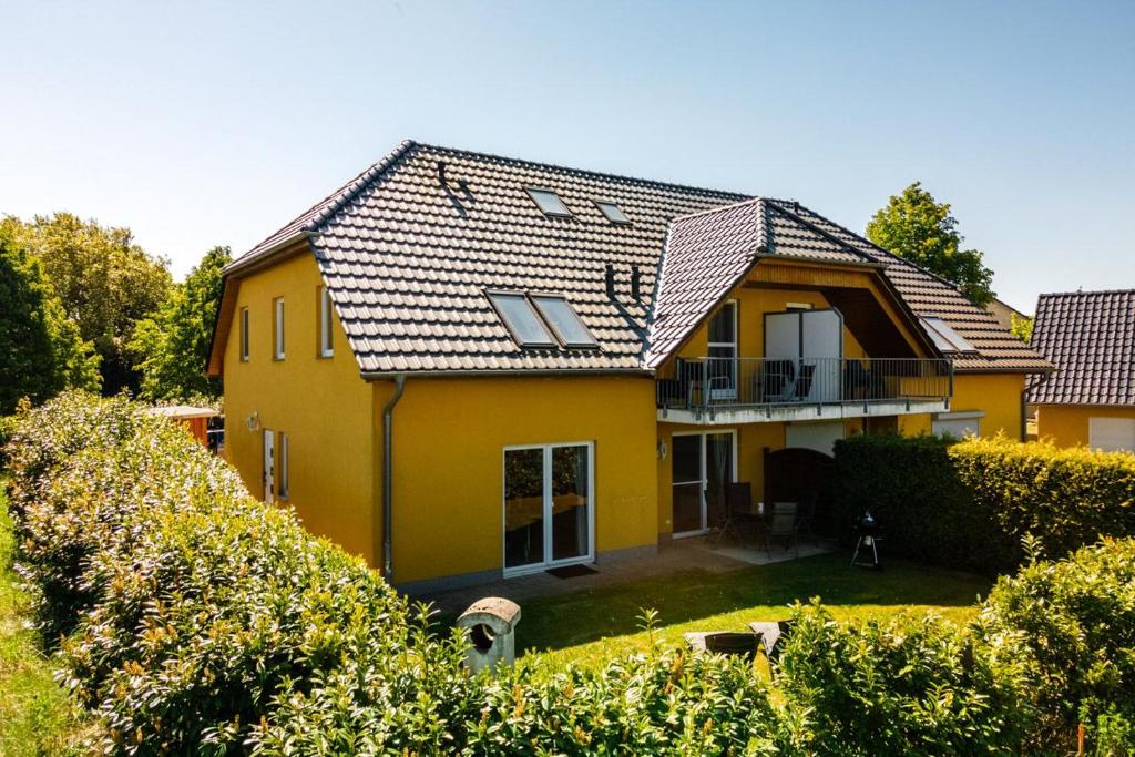 a yellow house with a roof at One Putt Erdgeschoss in Göhren-Lebbin