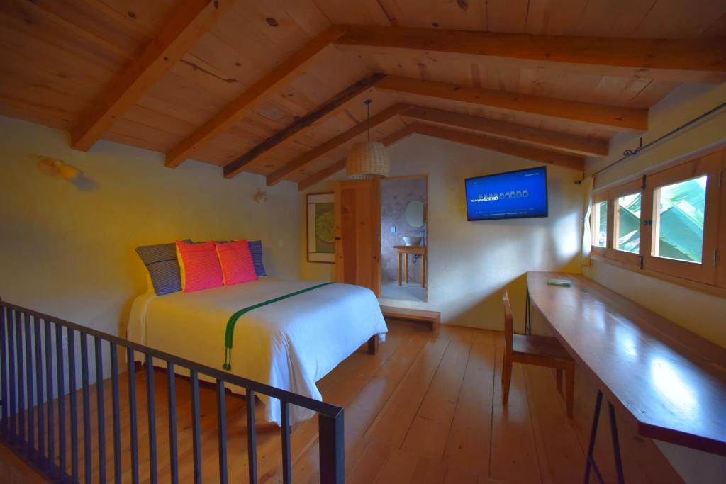 a bedroom with a bed and a tv in a room at Las Casas Chiapas in San Cristóbal de Las Casas
