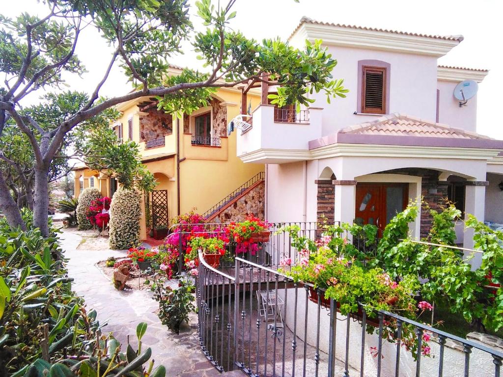 a house with flowers in front of it at Real B&B Primo Sole in Castelsardo