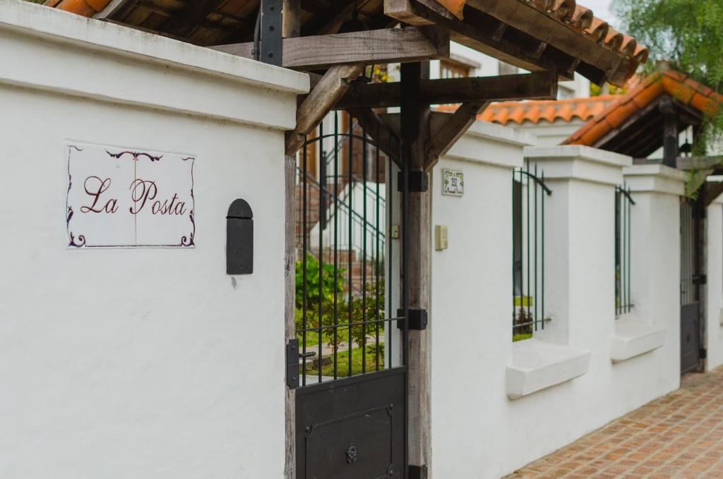 a white building with a black door with a sign on it at La Posta Tigre in Tigre