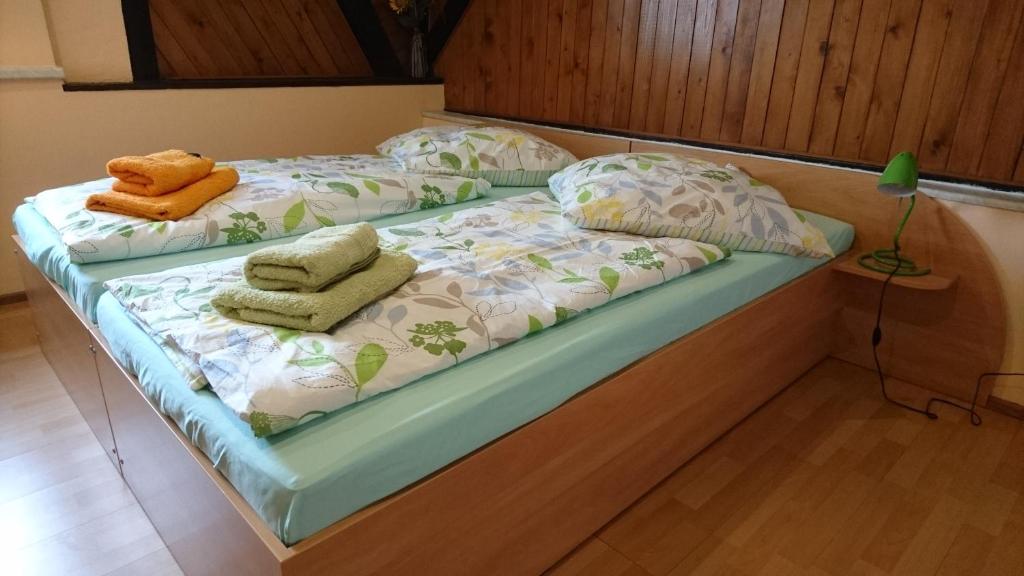 ein Bett mit zwei Kissen und Handtüchern darauf in der Unterkunft Heidebistro in Commerau