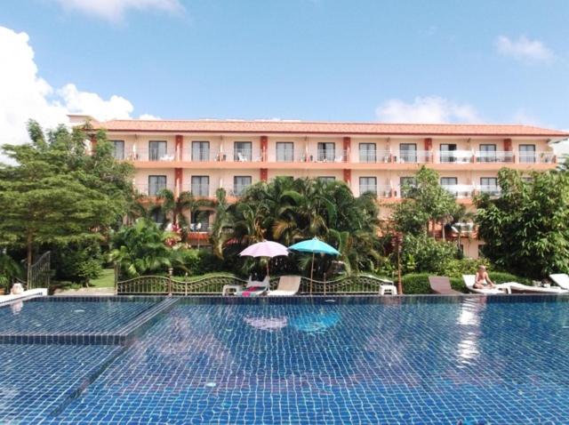 查汶的住宿－PTK公寓酒店，一座大型建筑,在一座建筑前设有一个游泳池