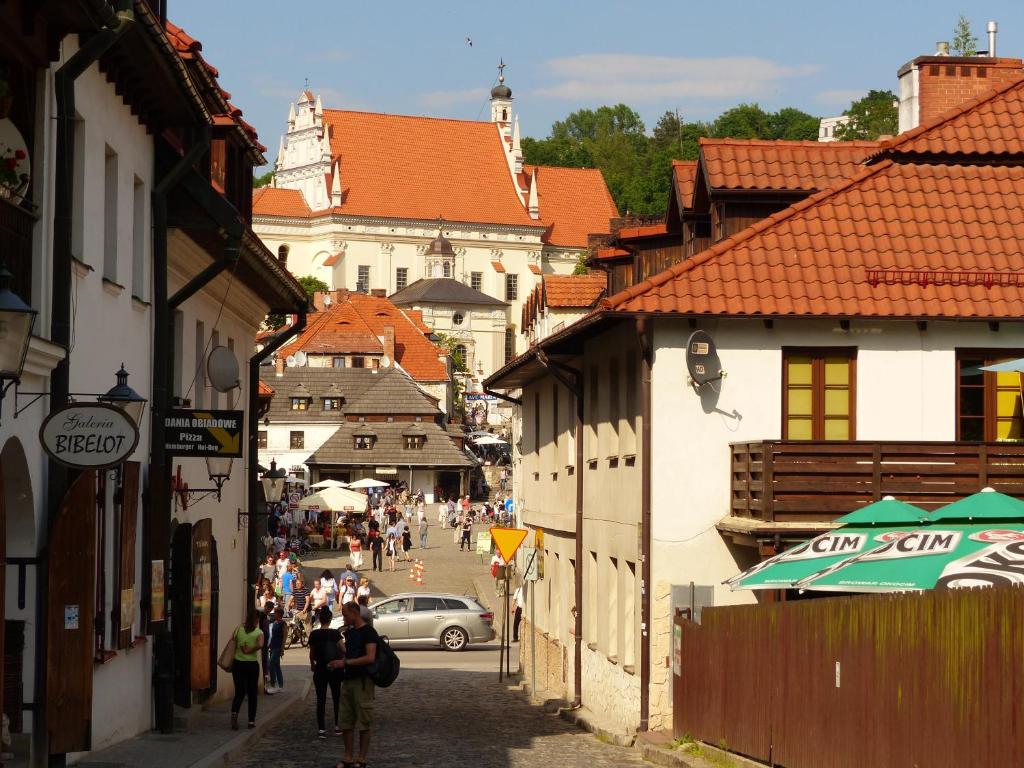 Un grupo de personas caminando por una calle con edificios. en Apartament 10 Poranek - Pod Aniołem, en Kazimierz Dolny