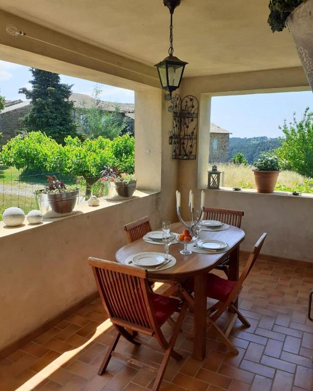 une salle à manger avec une table et des chaises et une fenêtre dans l'établissement Maison de campagne - Proche Aubenas et Vals les Bains, à Saint-Julien-du-Serre